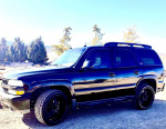 Black 2005 Chevrolet Tahoe LS 4WD parked outdoors, featuring custom wheels and a sunroof.
