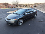 2010 Honda Civic EX Coupe with premium wheels parked in a residential area, showcasing its sleek design and low mileage.