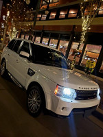 2012 Land Rover Range Rover HSE 4WD parked on a busy street adorned with lights at night