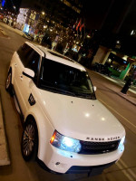2012 Land Rover Range Rover Sport HSE parked at night with city lights in the background