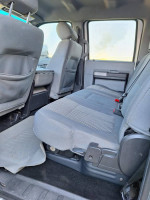 Interior view of a 2016 Ford F250 Super Duty with grey cloth seats and spacious back seat area.