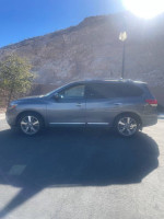 Side view of a 2016 Nissan Pathfinder Platinum FWD parked with a mountain backdrop