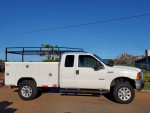 2006 Ford F250 Turbo Diesel 4x4 utility truck with a clean exterior and custom features parked outdoors.