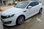 2012 Kia Optima SX FWD shown parked, featuring white exterior, 18-inch rims, and sporty design.