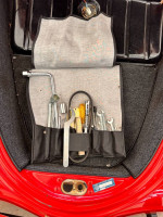 Tools neatly organized in a roll-up case inside a Porsche Speedster trunk
