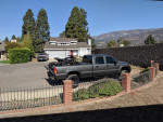 2002 GMC Sierra 2500 Duramax truck parked in residential area with motorcycles loaded in the bed